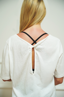 Women's open-back everyday tee with crossover straps, front view on model — DWEGO